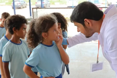 Governo Federal - Profissional de saúde em ação educativa com estudantes, promovendo hábitos saudáveis nas escolas públicas