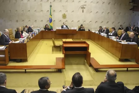 Prédio do Supremo Tribunal Federal com ministros discutindo julgamento sobre símbolos religiosos em órgãos públicos