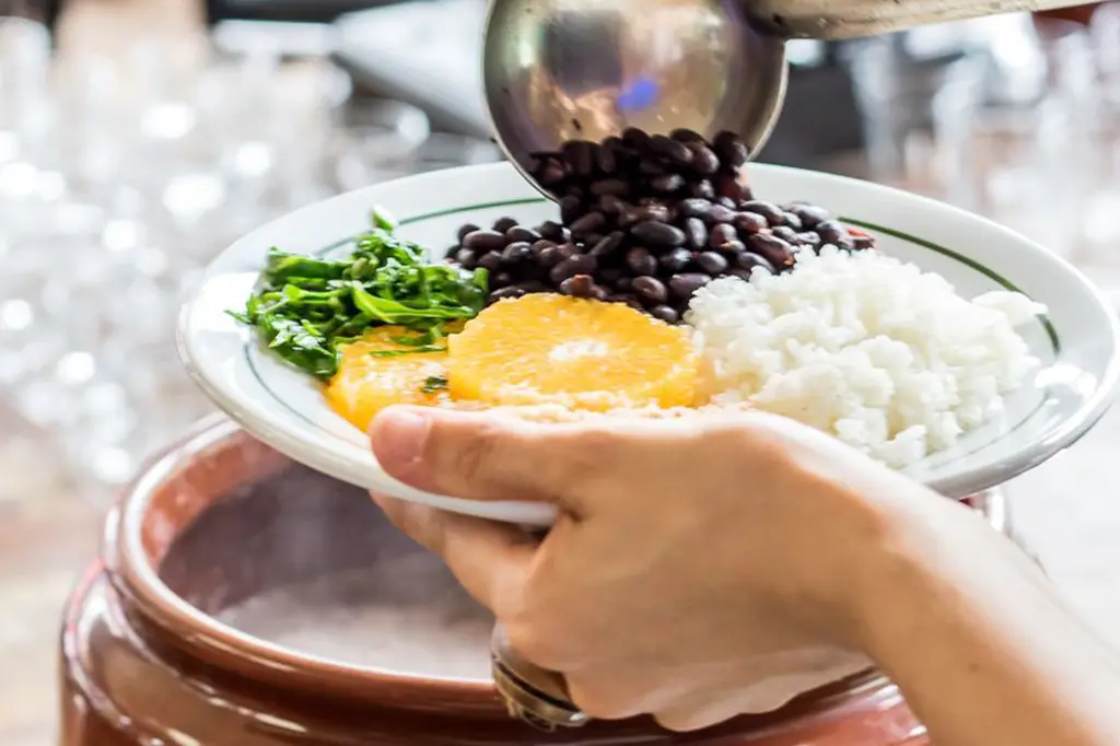 Mesa com feijoada sendo servida em evento beneficente no Boteco São Bento, Santo André, promovido pelo Villa Solidária.