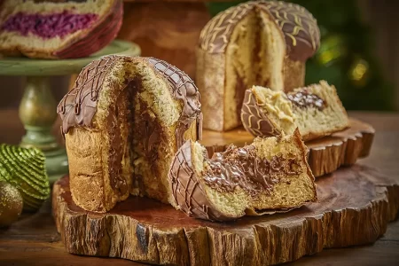 "Panetone Frutas Vermelhas da Padaria Brasileira com cobertura de chocolate meio amargo e decoração vermelha."