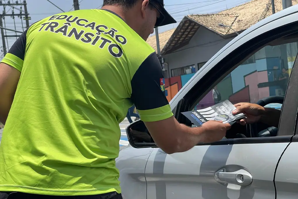 Agente de trânsito orientando pedestres em ação educativa em Ribeirão Pires.