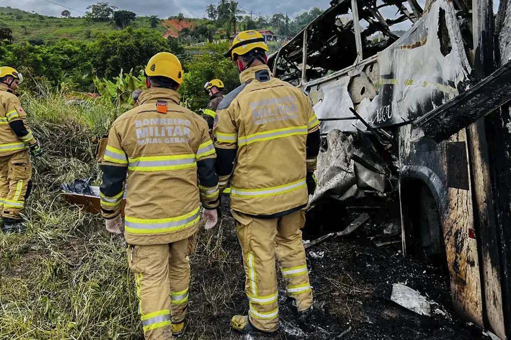 Destroços do ônibus incendiado após colisão com carreta na BR-116 em Minas Gerais.