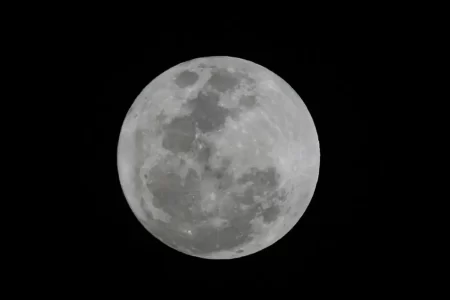 Imagem de uma chuva de meteoros iluminando o céu noturno.