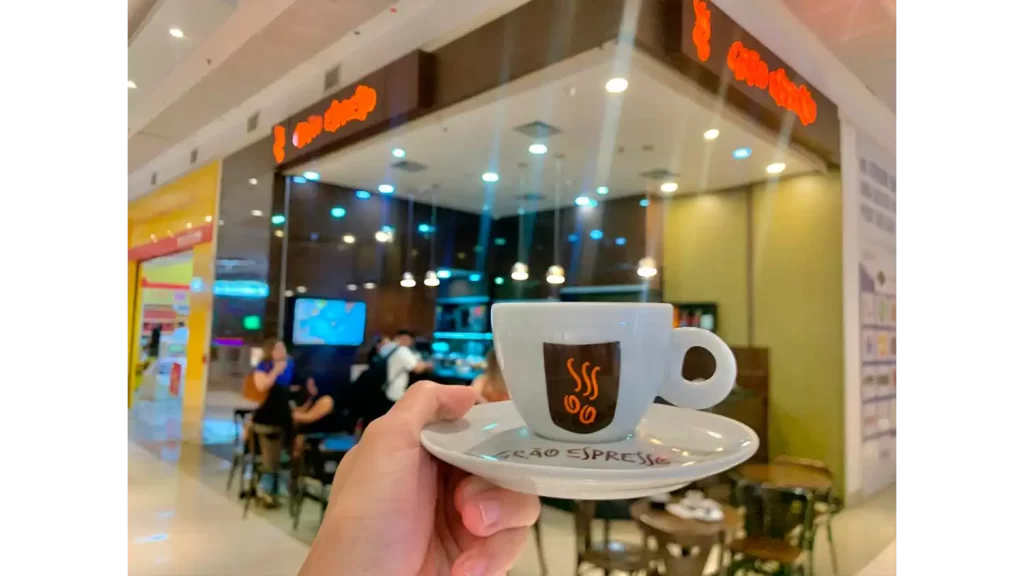 Atrium Shopping é destino para quem procura os melhores cafés de Santo André 4 Ambiente aconchegante de uma cafeteria no Atrium Shopping, com uma xícara de café e um bolo fresco sobre a mesa.