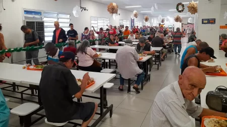 Pessoas sendo atendidas na Caravana da Saúde no Bom Prato Centro, com serviços de assistência e saúde disponíveis gratuitamente.
