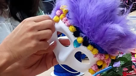 Crianças e famílias se divertindo em atividade carnavalesca com música, fantasias e oficina de máscaras no Parque Villa-Lobos.