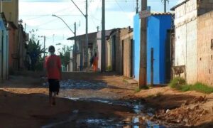 Adolescentes caminham em rua de bairro periférico de São Paulo; estudo mostra impacto da violência e da infraestrutura na percepção de justiça