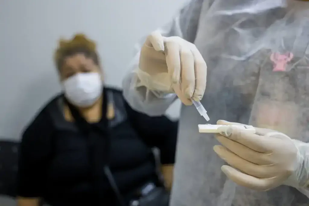 Profissional de saúde realiza teste rápido de gripe em paciente no Hospital Albert Sabin, em São Caetano do Sul