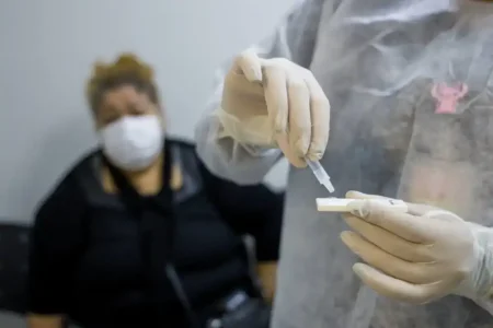 Profissional de saúde realiza teste rápido de gripe em paciente no Hospital Albert Sabin, em São Caetano do Sul