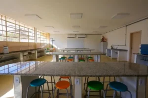 Sala de aula reformada em escola estadual de São Paulo com ar-condicionado instalado e nova pintura nas paredes.
