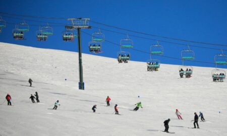Vista panorâmica do Cerro Catedral em Bariloche, com neve e turistas brasileiros durante o inverno