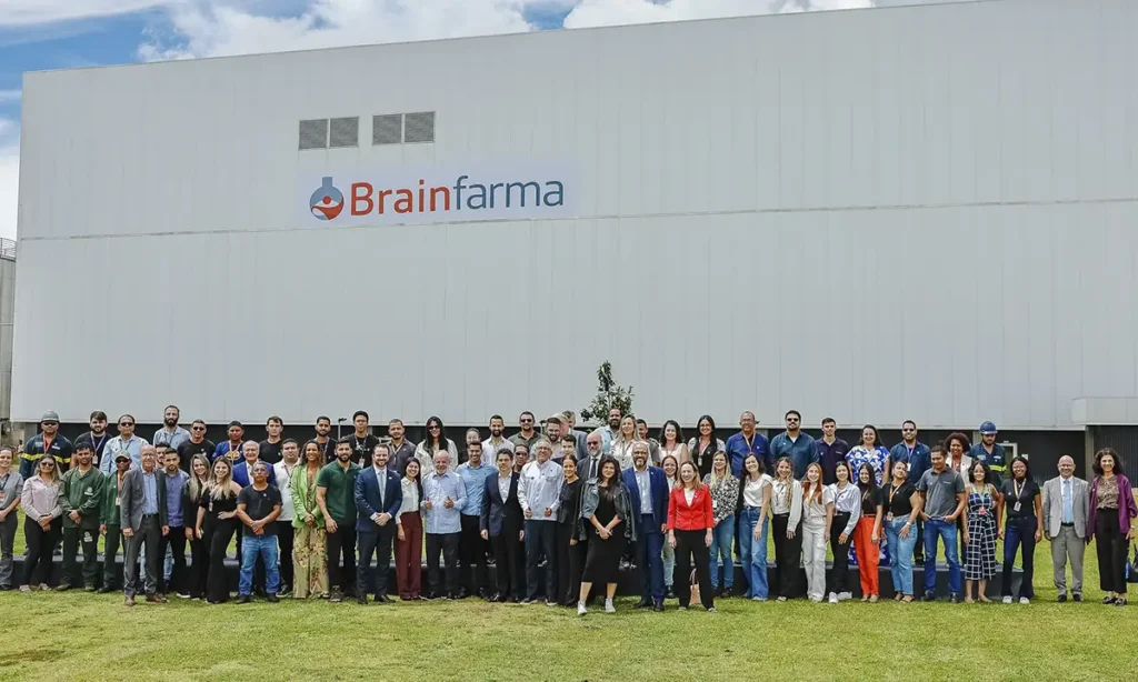 Lula em Anápolis: “Investir na saúde não é gasto”, diz presidente ao anunciar fábrica de R$ 250 milhões Presidente Lula ao lado de ministros e diretores da Brainfarma em frente a maquinário industrial farmacêutico.